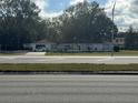 White ranch home with a large yard and road frontage at 17048 State Road 54, Lutz, FL 33558