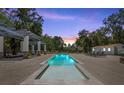 A beautiful pool view with an outdoor pergola and several lounge chairs next to a pool house at 18102 Livingston Ave, Lutz, FL 33559