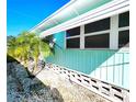 Side view of the light blue manufactured home, showcasing its clean exterior and landscaping at 34483 Cactus N Dr, Pinellas Park, FL 33781