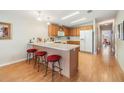 Kitchen with light wood cabinets, white appliances, and a breakfast bar at 37539 Gill Ave, Zephyrhills, FL 33541