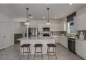 Modern kitchen with white cabinets, island, stainless steel appliances, and quartz countertops at 4177 Feldspar Ln, Spring Hill, FL 34609