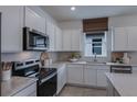 Modern kitchen with white cabinets, stainless steel appliances, and quartz countertops at 4177 Feldspar Ln, Spring Hill, FL 34609