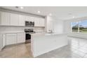 Modern kitchen with white cabinets and island at 12213 Tranquil Waters Ter, Parrish, FL 34219