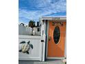 Welcoming orange front door of beach cottage at 13708 Salem St, Madeira Beach, FL 33708