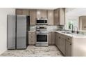 Modern kitchen with stainless steel appliances and light wood cabinets at 14198 89Th Ave, Seminole, FL 33776