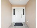 White front door with sidelights and a dark welcome mat at 4303 Waltham Ln, New Port Richey, FL 34653