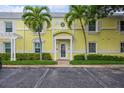 Exterior view of yellow building with palm trees and parking at 5005 Coquina Key Se Dr # E, St Petersburg, FL 33705