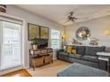 Living room with gray couch, TV, and access to balcony at 5005 Coquina Key Se Dr # E, St Petersburg, FL 33705