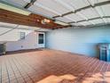 Attached garage with tiled floor, open door, and additional storage area at 11824 Cypress Crest Cir, Tampa, FL 33626