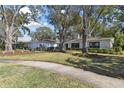 House exterior, showcasing a landscaped yard and large trees at 11905 Trevino Pl, Tampa, FL 33624