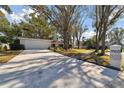 Front view of the house with a long driveway and address marker at 11905 Trevino Pl, Tampa, FL 33624