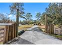 Long gravel driveway leading to a two-story house at 14450 Lancer Rd, Spring Hill, FL 34610