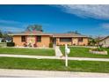 Single story home with stone accents, landscaped yard, and a two car garage at 153 Sunward Ave, Palm Harbor, FL 34684