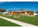 Single story home with stone accents, landscaped yard, and a two car garage at 153 Sunward Ave, Palm Harbor, FL 34684