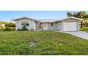 Newly renovated home with gray exterior, white garage door, and manicured lawn at 159 Danforth Dr, Punta Gorda, FL 33980
