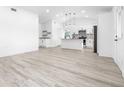 Modern kitchen with white cabinets, an island, and wood-look floors at 2859 38Th N Ave, St Petersburg, FL 33713