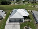 Single-story home with metal roof, three-car garage, and golf course view at 676 Allegheny Dr, Sun City Center, FL 33573