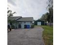 Home's side view, showing a detached garage and driveway at 905 10Th Sw St, Ruskin, FL 33570