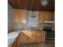 L-shaped kitchen with wood cabinets and granite countertops at 905 10Th Sw St, Ruskin, FL 33570