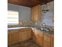L-shaped kitchen with wood cabinets and granite countertops at 905 10Th Sw St, Ruskin, FL 33570