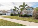 House exterior showcasing white walls, a gray roof, and lush landscaping at 1028 Wyndham Way, Safety Harbor, FL 34695