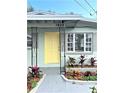 House exterior featuring a yellow door and landscaping at 1605 E Bougainvillea Ave, Tampa, FL 33612
