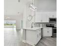 Modern white kitchen with stainless steel appliances and an island at 1709 Edgewater Ln, Palmetto, FL 34221