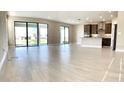 Open living room with tile floor and sliding glass doors at 4861 Tramanto Ln, Wesley Chapel, FL 33543
