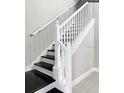 Modern staircase with white railing and dark wood steps at 4861 Tramanto Ln, Wesley Chapel, FL 33543