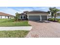 Two-story house with a three-car garage and landscaped front yard at 5287 Rushmere Ct, Palmetto, FL 34221