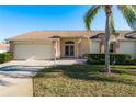 Brick home with two-car garage, double doors, and landscaped yard at 1116 Flora Vista St, Trinity, FL 34655