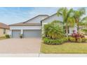 Two-story house with gray siding, three-car garage, and lush landscaping at 11714 Sunburst Marble Rd, Riverview, FL 33579