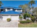 Two-story home with blue metal roof and driveway at 1621 Watermark Ne Cir # 1621, St Petersburg, FL 33702