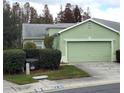 Light green house with a two-car garage and well-manicured landscaping at 20841 Eustis Rd, Land O Lakes, FL 34637