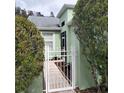 Pathway to the entrance of a light green house with lush landscaping at 20841 Eustis Rd, Land O Lakes, FL 34637