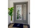 Gray front door with stained glass accents and a welcoming entry mat at 2357 Emerald Lake Dr, Sun City Center, FL 33573