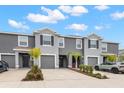 Two-story townhome with gray exterior, two-car garage, and landscaping at 32174 Turtle Grace Loop, Wesley Chapel, FL 33545