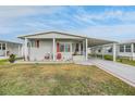 Single-wide manufactured home with covered porch and driveway at 36901 Kimela Ave, Zephyrhills, FL 33542