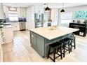 Modern kitchen featuring an island, stainless steel appliances, and light wood flooring at 3909 W Eden Roc Cir, Tampa, FL 33634
