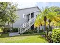 Gray condo building with exterior stairs and landscaping at 11847 Skylake Pl # D, Tampa, FL 33617