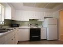 Bright kitchen featuring white cabinets, appliances, and a microwave at 1469 Normandy Park Dr # 1, Clearwater, FL 33756