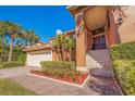 Grand entrance with tiled stairs and manicured landscaping at 207 8Th E St, Tierra Verde, FL 33715