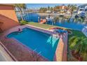 Inviting rectangular pool with brick patio and canal views at 207 8Th E St, Tierra Verde, FL 33715