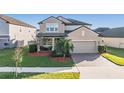 Two-story house with landscaped yard and two-car garage at 30868 Kelmin Ter, Wesley Chapel, FL 33543