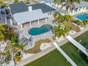 An aerial view of a waterfront home with a pool and private dock at 65 Dolphin Dr, Treasure Island, FL 33706