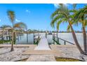 Private boat dock on a calm waterway with palm trees at 65 Dolphin Dr, Treasure Island, FL 33706