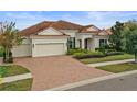 Single-Gathering home with a brick driveway and a well-manicured lawn at 11910 Climbing Fern Ave, Riverview, FL 33579