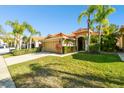 Two-story house with a tan exterior and palm trees at 14608 Mirasol Manor Ct, Tampa, FL 33626