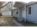 Gray house with a detached garage, and a small front yard at 1575 S Martin Luther King Jr Ave, Clearwater, FL 33756