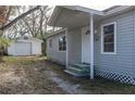 Gray house with a detached garage, and a small front yard at 1575 S Martin Luther King Jr Ave, Clearwater, FL 33756